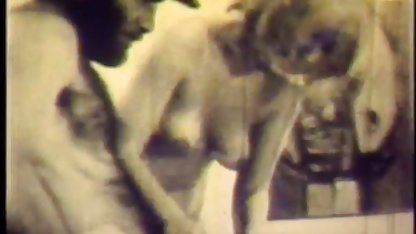 Killen fingrar en fet kvinna i en svensk 80 tals porr gasmask med en tatuering på fitta